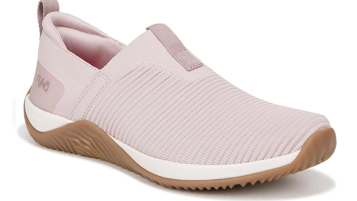A blush pink slip-on sneaker with a textured knit upper, white and gum rubber sole, and a minimalist design, ideal for casual wear and light walking.